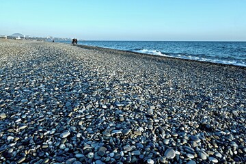 sea coast with pebble beach and city