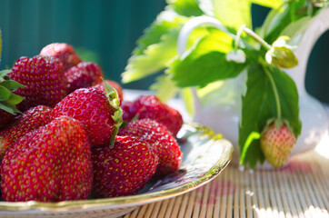 Freshly cut strawberries on a wooden cutting board and delicious strawberries in a glass bowl on wooden table. Season's fruit. Healthy food. Wooden background. Ecological and organic food. Agriculture