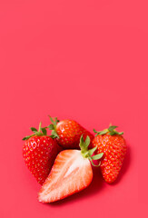 Ripe juicy orgaic strawberries on a red background.
