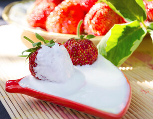 Freshly cut strawberries on a wooden cutting board and delicious strawberries in a glass bowl on wooden table. Season's fruit. Healthy food. Wooden background. Ecological and organic food. Agriculture