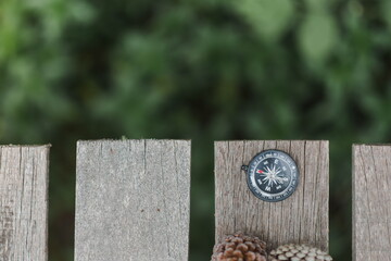 a compass on the wooden plate in the forest