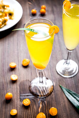 cocktail with physalis in glass on wooden background
