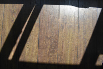 The shadow of the window on the dark wooden floor