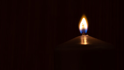 Fototapeta premium burning candle on black background for copy space. Memorial concept