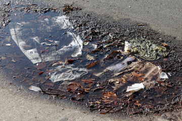 Litter collects as flotsam in a puddle on Spring Garden street in Philadelphia's Callowhill neighborhood.