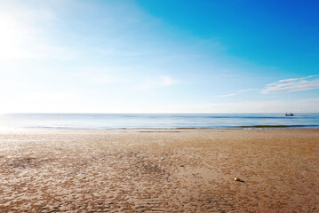 Fototapeta na wymiar Morning seaside beach clam waves with blue sky background.