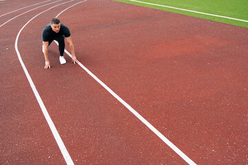The runner prepared to run. The sprinter sits at the start on treadmill at the stadium. The concept of athletics in sport