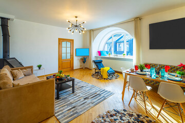 Modern interior of spacious living room in studio apartment. Comfortable furniture. Private house. Lounge chair. Set table.