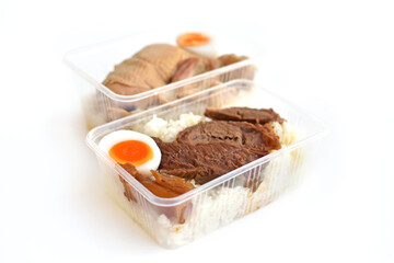 Stewed beef with rice in a plastic container ready to eat