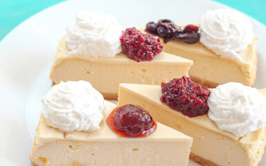 portion of cheesecake with jam on a white plate with cream