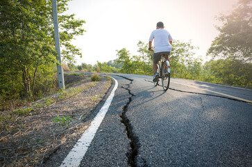 The man ride on bike on the broken road in the park. Sport and active life concept.
