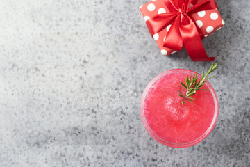 Shimmer edible glitter sparkling rose wine garnish rosemary on grey. View from above.