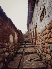 A street in Urubamba, Peru. Traditional house built on stones, with wooden doors and windows.