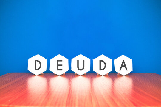 deuda endeudamiento palabra hexagono pared madera azul blanco letras reflejo texto