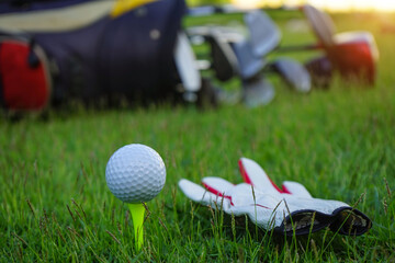 Golf ball on tee ready to be shot. golf ball on tee in the evening golf course with sunshine.