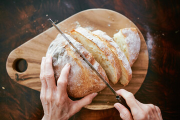 cutting freshly baked bread on rustic wooden table