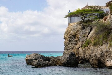 Naklejka premium Coastal Cliffs and Local Fisherman in Curacao