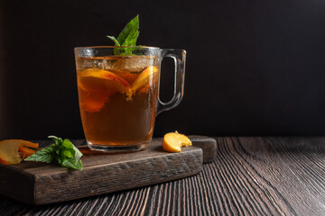Ice tea with peach and mint on wooden table.  Horizontal orientation. Copy space. 