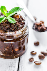 Homemade cosmetics with scrub and coffee beans on desk background