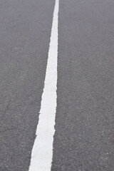 White solid line on asphalt road. Carriageway marking