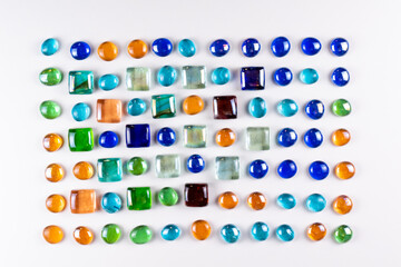 Decorative layout of colored glass on a white background top view