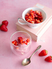 Strawberry ice cream in a glass cup on a pink background. Yogurt ice cream. Diet, healthy eating. Fresh strawberries. Copy space, close up.