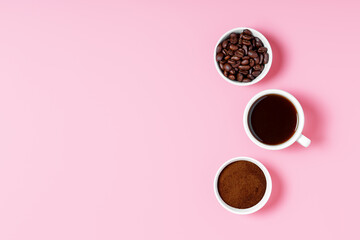 coffee beans, ground and black coffee or espresso in mugs on a pink background. coffee shop or store concept. concept of making coffee. copy space, top view, minimalism.