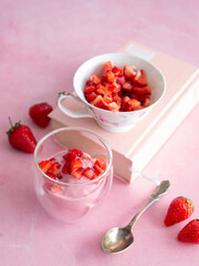 Strawberry ice cream in a glass cup on a pink background. Yogurt ice cream. Diet, healthy eating. Fresh strawberries. Copy space, close up.