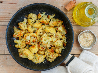 Roasted cauliflower with olive oil, sesame seed, dill and spices. Tasty snack. Vegetarian dish. Rustic style. Selective focus