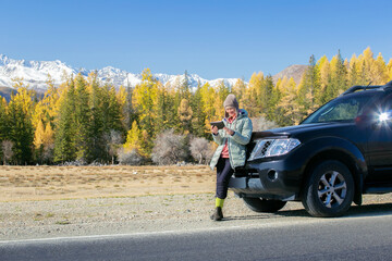 Traveler woman using tablet on mountains road trip. Auto travel concept.