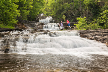 a couple of hikers climbing a waterfall
