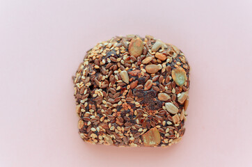 Sliced whole grain bread rye with seeds flax, sunflower, pumpkin and sesame.Healthy food, eco-friendly natural products. Fresh bread on a pink background.