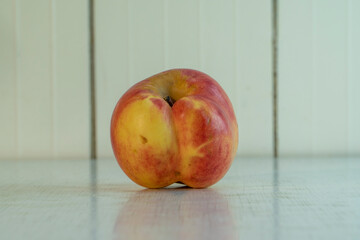 Siamese twins apple reflected in the white rustic table in the home. Organic fruit good for diet, because contain a lot of vitamins and microelements. Landscape orientation image with copy space.