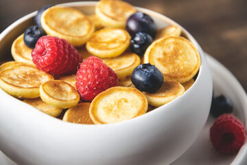 Food cooking trend, pancake cereal, tiny pancakes with raspberry, blueberry