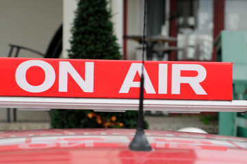 red On Air sign with white letters