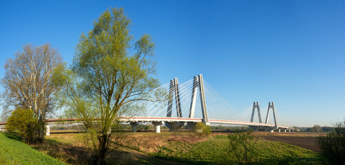 Modern double cable-stayed bridge over Vistula River in Krakow, Poland. Wide panorama in sunrise...