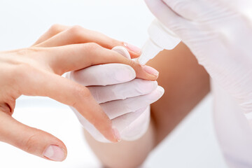 Manicure specialist applying glue for nail of woman close up. Manicurist uses manicure tool.