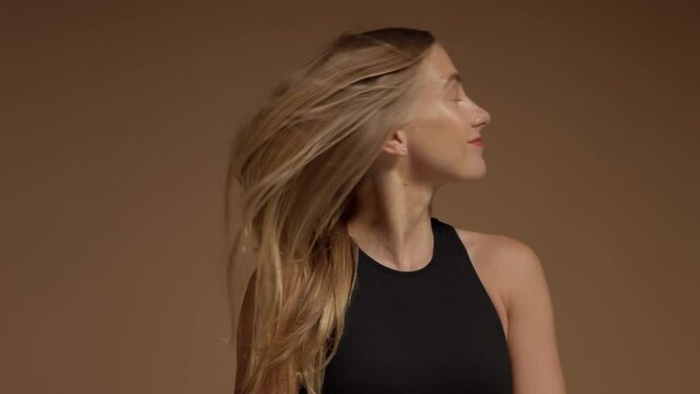 side view of young blonde model shake her head and hair flying then laughing slow motion from 60 fps