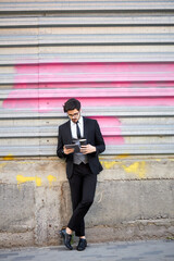 Young Businessman using a tablet pc outside wearing a classic suit