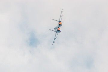 Jet fighter displaying during air show and showing afterburners
