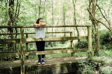 Girl posing on a wooden bridge in a forest
