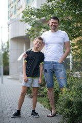 Obraz premium Father and son walking outdoors in summer on the street