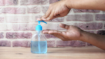 man's hands using hand sanitizer gel, close up