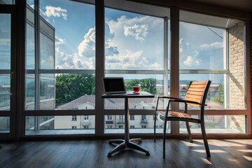 interior view of chair and table with laptop near glass wall 