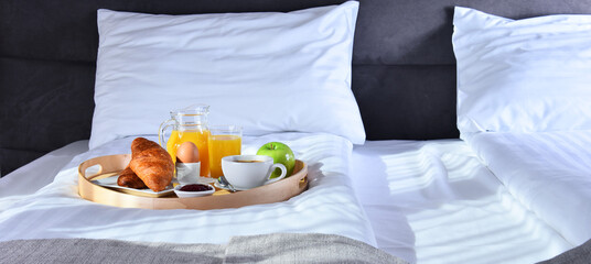 Breakfast on tray in bed in hotel room