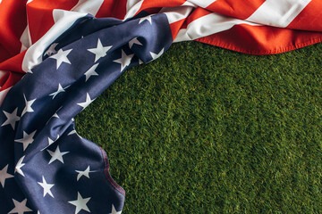 top view of american flag with stars and stripes on green grass outside, labor day concept