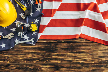 top view of instruments and safety helmet on american flag and wooden surface, labor day concept