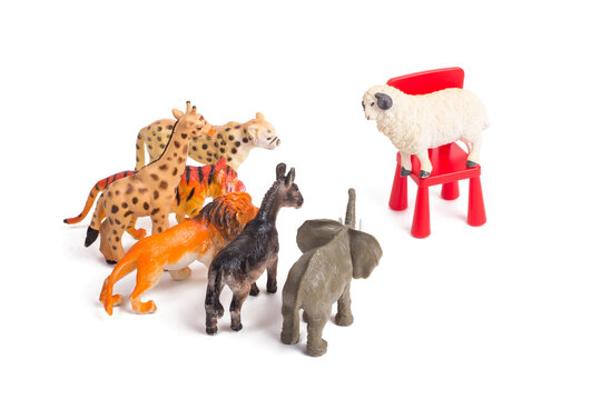 Toy plastic figurines of animals on white isolated background. One against all. Crowd of animals in front of their leader. Leadership concept. Speech to the people. Following the charismatic leader.