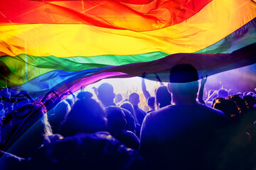 silhouette of a parade of gays and lesbians with a rainbow flag - symbol of love and tolerance