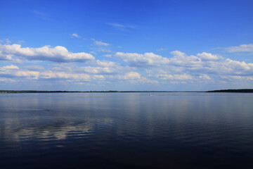 Fototapeta premium Landscape with a lake and white clouds on a blue sky